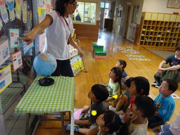 担任の先生と地球儀や国についての掲示を見ているところ